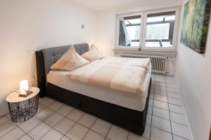 a small bed in a room with a window at Ferienwohnung Villa Abrioux am Park in Bad Bertrich