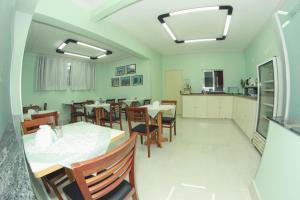 a kitchen and dining room with a table and chairs at Alpha Ville Hotel in Assis