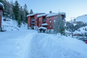 a snow covered road in front of a building at Cocon à la Plagne in Plagne 1800