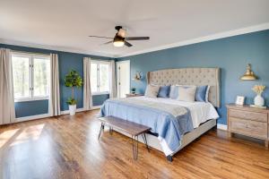 ein blaues Schlafzimmer mit einem Bett und einem Deckenventilator in der Unterkunft Spacious Waterfront Hyco Lake Retreat with Dock! in Roxboro