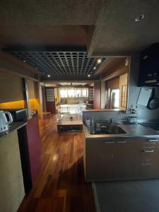 a large kitchen with wooden floors and a kitchen with a sink at Guest House Tokyo Samurai in Tokyo