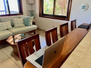 a living room with a laptop on a wooden table at Bella Sway Belize in Placencia