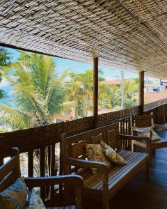 a porch with benches and a view of the beach at Pousada da Praia in Paraty