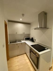 cocina con armarios blancos y fogones en Spacious 1 bedroom apartment in Norwich city centre en Norwich