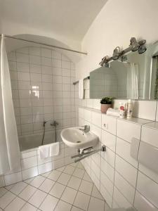 a white bathroom with a sink and a mirror at Apartment Sonnenterrasse in Bautzen +7 photos