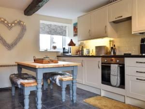 a kitchen with a blue table and stools at Meadow View Cottage - Uk33302 in Middleton