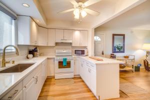 a kitchen with white cabinets and a ceiling fan at Hutchinson Island Vacation Rental with Beach Access! in Fort Pierce