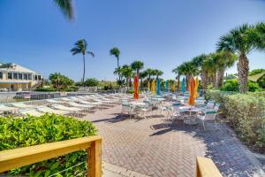 a group of tables and chairs with umbrellas and palm trees at Hutchinson Island Vacation Rental with Beach Access! in Fort Pierce