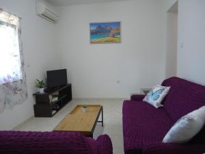 uma sala de estar com um sofá roxo e uma mesa de centro em HOLI em Čavle