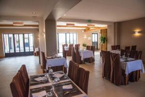 a restaurant with tables and chairs in a room at Auberge du Moulin à Vent, The Originals Relais in Manou