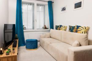 un salon avec un canapé et une télévision dans l'établissement Le Pied à Terre de la Cité - Parking au Pied de la Cité, à Carcassonne