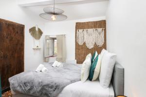 une chambre avec un lit avec des draps blancs et des oreillers dans l'établissement Le Pied à Terre de la Cité - Parking au Pied de la Cité, à Carcassonne