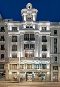 a large white building with a clock tower at Boutique Hotel H10 Villa de la Reina in Madrid