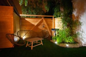 un patio con panca e tavolo con luci di Private Paradise on cozy Campsite, Jacuzzi, Netflix a Las Galletas