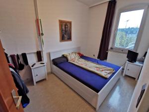 1 dormitorio con 1 cama con colchón azul y ventana en NearWöhrderSeaAndStation, en Núremberg