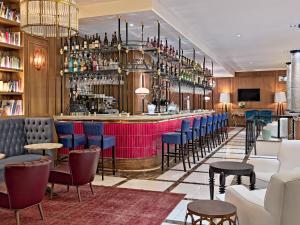a bar in a restaurant with blue and red chairs at Boutique Hotel H10 Villa de la Reina in Madrid