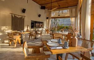 图卢姆Hotel Muaré Tulum Wellness and Spa的一间带木桌和椅子的餐厅以及庭院