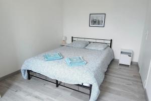 una camera da letto con un letto e due asciugamani di Bel appartement centre ville. a Blaye