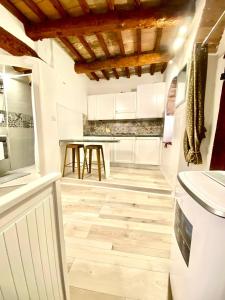 eine Küche mit weißen Schränken und Holzböden in der Unterkunft Perugia Mini Flat in Perugia