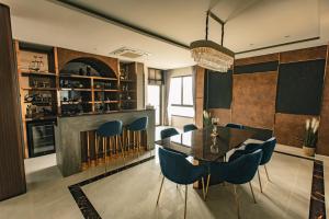 Nong Prue的住宿－Astro Luxury: Ultra Luxury 4 Beds Pool Villa，一间带桌子和蓝色椅子的用餐室