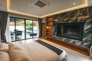 een grote woonkamer met een open haard en een bank bij Astro Luxury: Ultra Luxury 4 Beds Pool Villa in Nong Prue