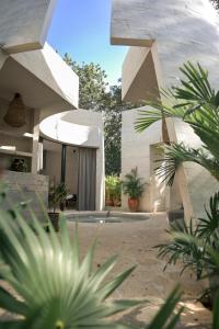 - une vue sur une maison avec des plantes devant elle dans l'établissement Hotel Muaré & Spa Tulum, à Tulum