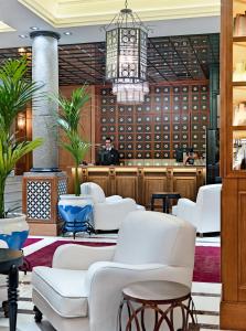 een wachtkamer met witte stoelen en een kroonluchter bij Boutique Hotel H10 Villa de la Reina in Madrid