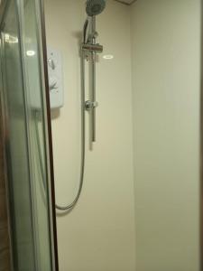 a shower in a bathroom with a glass door at Modern Apartment with Roof Garden Close to City Centre in Cardiff