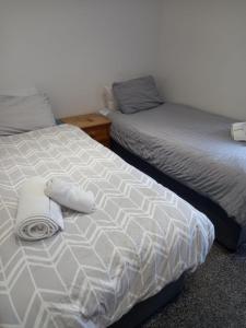 two beds sitting next to each other in a bedroom at Modern Apartment with Roof Garden Close to City Centre in Cardiff