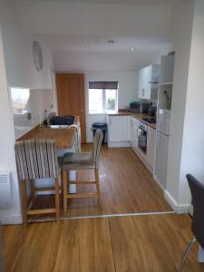 a kitchen with a table and chairs in a room at Modern Apartment with Roof Garden Close to City Centre in Cardiff