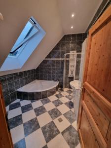a attic bathroom with a shower and a tub at Pension DonauBlick Grein 2 in Stifterstrasse 19A in Grein