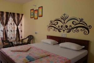 a bedroom with a bed with a decorative headboard at Silver Moon Guest House in Mahabalipuram +53 photos