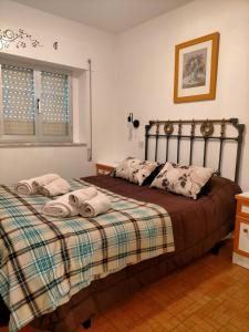 1 dormitorio con 1 cama con toallas en Bajo los nidos 2, en San Emiliano