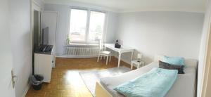 - un salon blanc avec un lit et un bureau dans l'établissement Ferienwohnung in Kronshagen Monteurwohnung 3 Zimmer 70 m2, Küche und Badezimmer, à Kronshagen