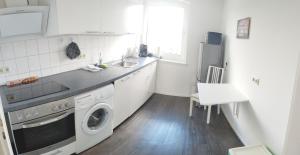a kitchen with a sink and a washing machine at Ferienwohnung in Kronshagen Monteurwohnung 3 Zimmer 70 m2, Küche und Badezimmer in Kronshagen