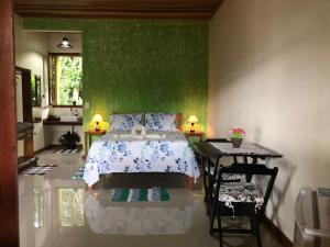 パラチにあるRecanto bela Vista caminho do ouroの緑の壁、ベッド付きのベッドルーム1室
