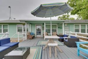 eine Terrasse mit einem Tisch und einem Sonnenschirm auf einem Haus in der Unterkunft Pet-Friendly Buchanan Lakefront Vacation Rental! in Tow