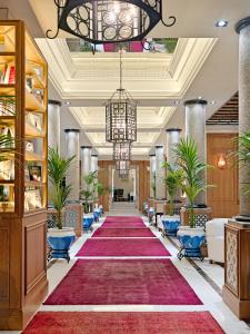 a large lobby with a red carpet and a chandelier at Boutique Hotel H10 Villa de la Reina in Madrid