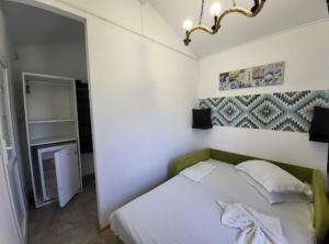 a small bedroom with a bed and a mirror at Mara si Marea in Năvodari