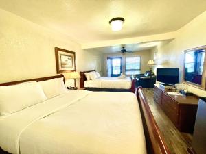 ein Hotelzimmer mit 2 Betten und einem TV in der Unterkunft Lake view queen Guest Room with two queens, sleeper sofa and deck overlooking Lake Ouachita, Hotel Room in Mount Ida