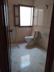 a bathroom with a toilet and a sink and a window at Superbe appartement chaleureux à 350m de la plage in M'diq