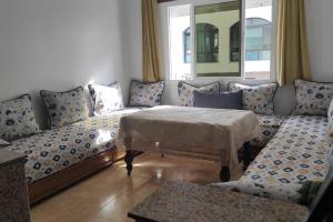 a living room with a couch and a table at Superbe appartement chaleureux à 350m de la plage in M'diq