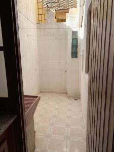 an empty hallway with a tile floor in a building at Superbe appartement chaleureux à 350m de la plage in M'diq