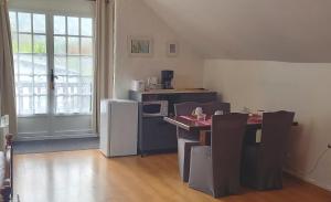 um quarto com uma cozinha com uma mesa e um frigorífico em Chambres d hôtes La Cavalière em Accous