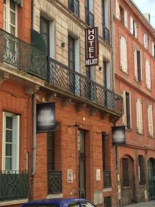 a brick building with a hotel district sign on it at Hôtel Héliot, Cosy Places by Charme & Caractère in Toulouse