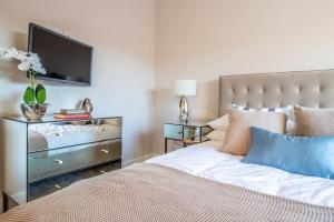 a bedroom with a bed and a flat screen tv at Luxurious newly built cottage in central Wivenhoe in Wivenhoe