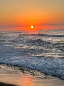 um pôr do sol na praia com o oceano em Aguada Beach Condos em Aguada