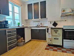 cocina grande con electrodomésticos blancos y suelo de madera en Mysigt hus med utsikt över fjäll och älv., en Järpen