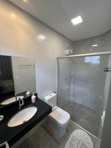 a bathroom with a toilet and a sink and a shower at Flats Ipê in Pirenópolis