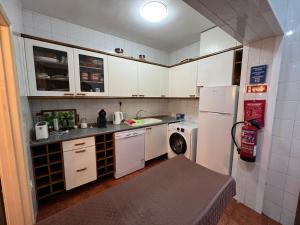 małą kuchnię z białymi szafkami i lodówką w obiekcie Casa rural em condomínio privado com piscina - Gerês w mieście Salamonde